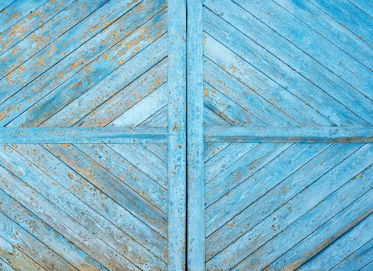 Photo. Barn door in old blue paint, diagonal boards