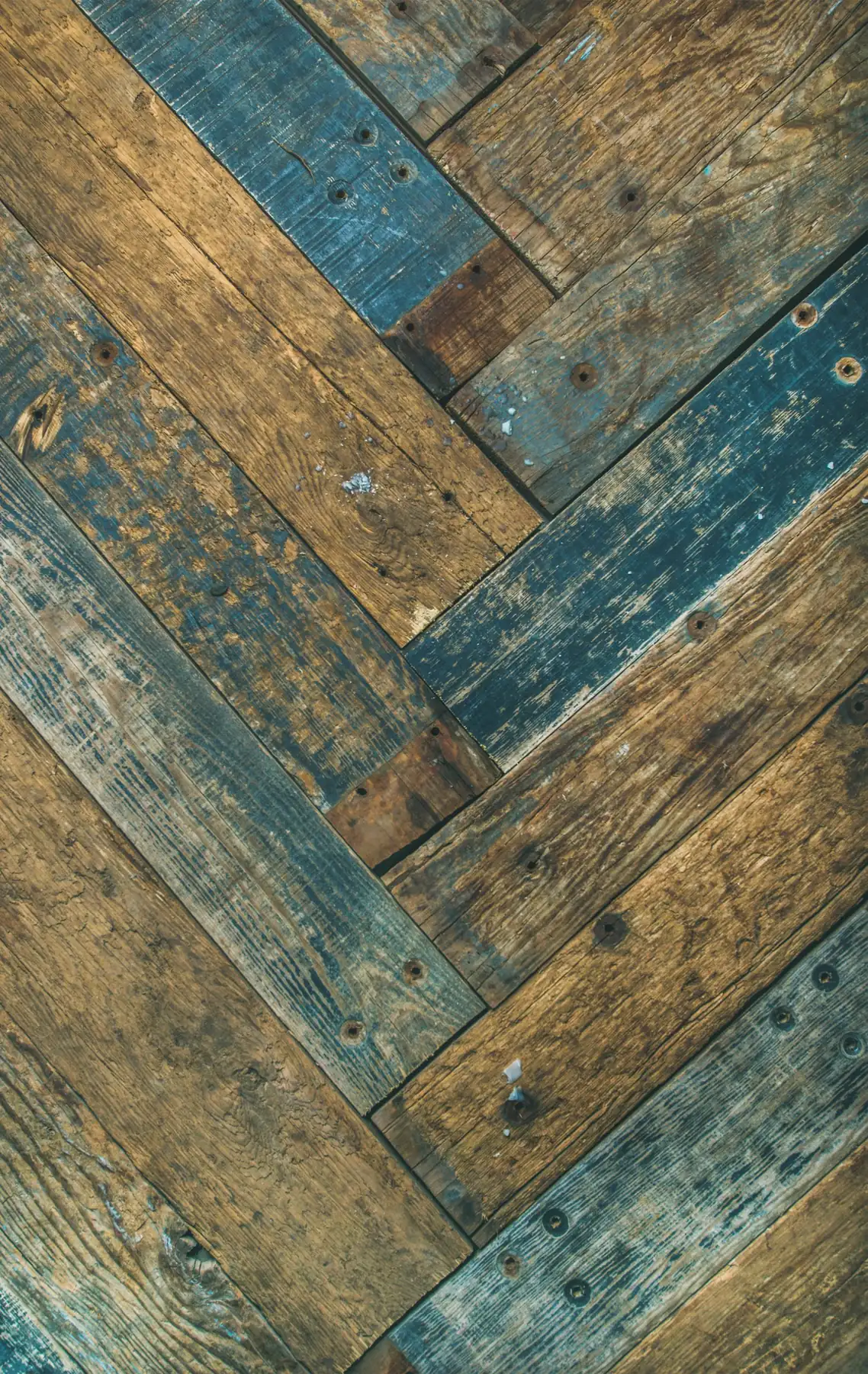 Photo. Reclaimed boards laid in herringbone, mixed tones